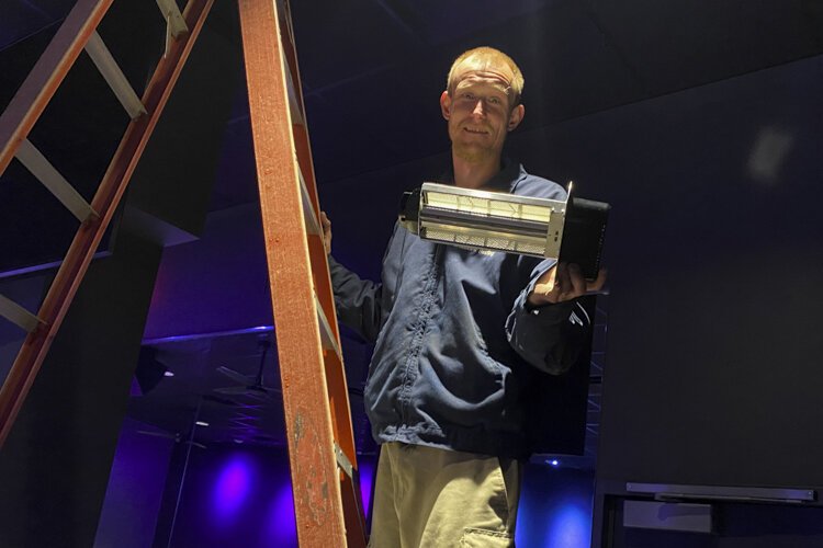 A technician installing the REME Halo unit at CycleBar.